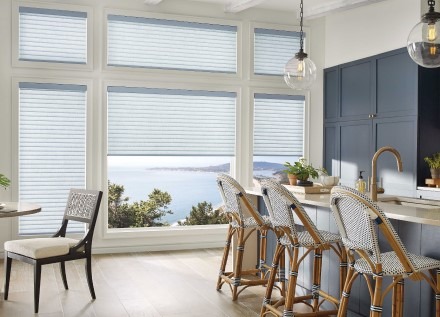 Well-lit kitchen with roller shades over window overlooking waterfront