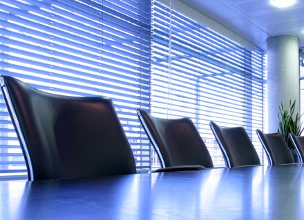 4 empty office chairs in front of window with blinds