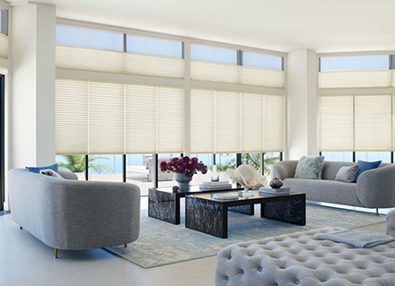 Large shades on large windows in a living room protect a home from bright sun, glare and fading.