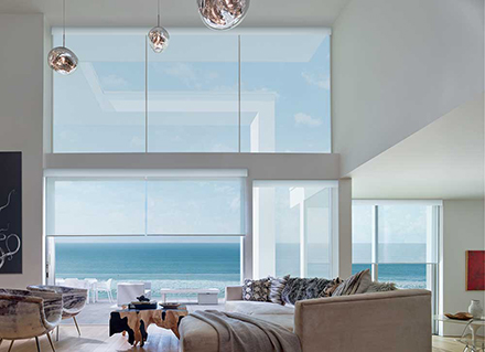 Beach view of rolling waves from large bay windows of a living room.