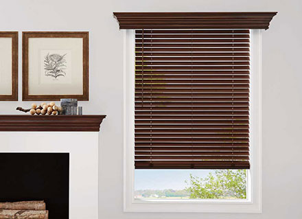 A dark wooden Parkland Wood blinds with cornices on a window overlooking a waterfront view to illustrate Cocoa Beach.