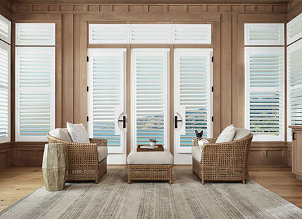 Plantation shutters on living room windows overlooking a water view.