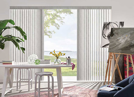 Vertical Blinds filter the light through a home office window overlooking a water view, illustrating Cocoa Beach.