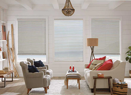 A light color Hunter Douglas Everwood Merritt Island Blinds illustration offers a look at sun control from a colorful living room over a waterfront view.