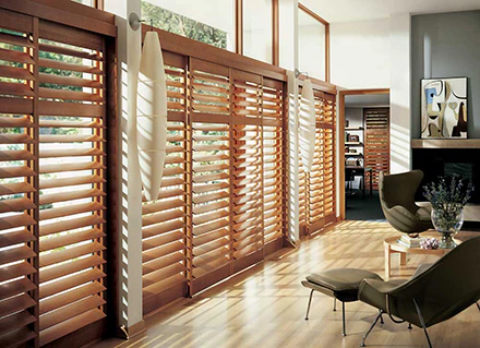 Red wood colored Heritance Lake Nona Plantation Shutters cover a home’s bay windows.