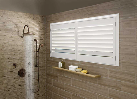 White Palm Beach Lake Nona Plantation Shutters cover a shower window inside a bathroom.