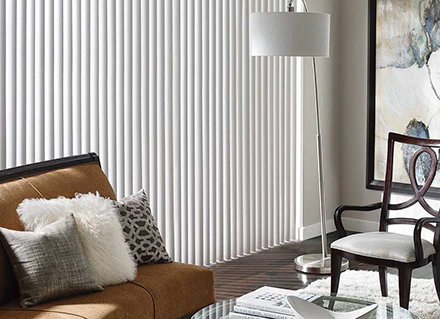 White vertical blinds inside a living room illustrate Lake Nona blinds window treatments.