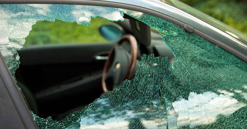 A vehicle without window security film has shattered glass after impact.