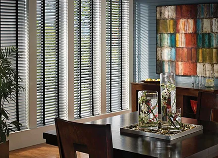 Metal Viera blinds cover a sliding glass door inside a home.