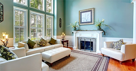Large bay windows cast light into a living room protected from the sun’s harsh effects by 3M Window Film.