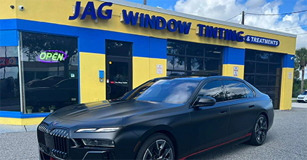 A black car is parked outside of JAG’s 3M Pro Shop location.